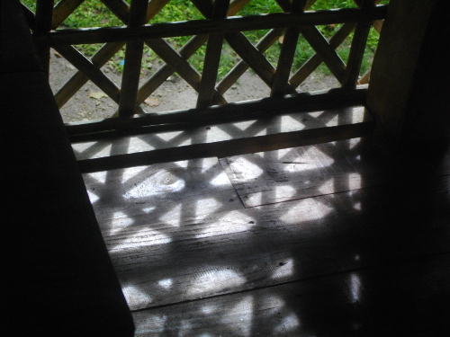 Image of sunlight shining through
        tropical baccony fence